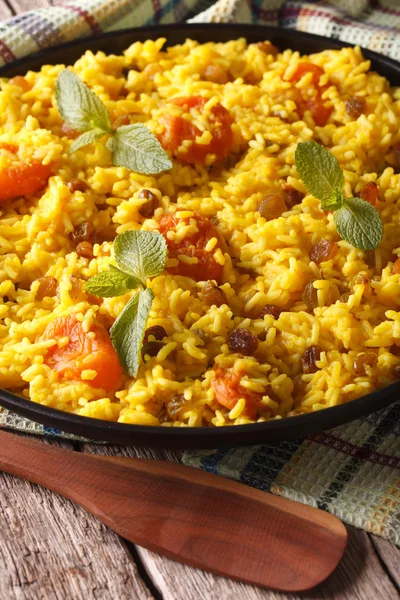 Arroz com açafrão e frutos secos close-up sobre a mesa. verticária — Fotografia de Stock