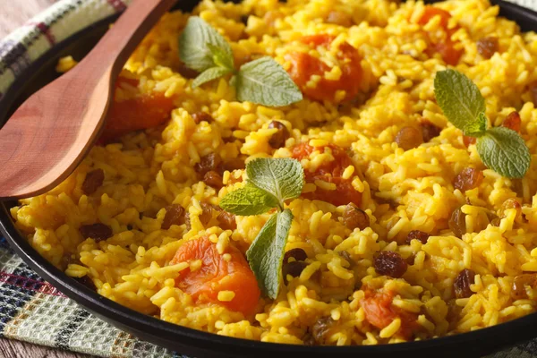 Arroz amarillo dulce con pasas y albaricoques secos macro. horizonte —  Fotos de Stock