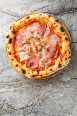 Prosciutto, salam, domates sosu ve ahşap tahtada mozzarella ile yakın plan Napoli pizzası. Taze kekik ile süslenmiş. Mermer arka plan. Yapay zeka değil. Yukarıdan dikey üst görünüm