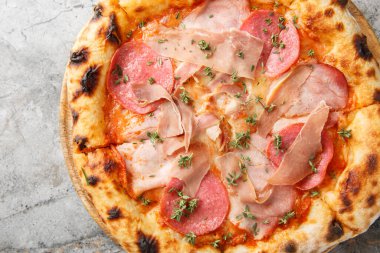 Jambon, jambon, jambon ve jambonlu kavrulmuş et pizzası masanın üstünde. Yukarıdan yatay üst görünüm