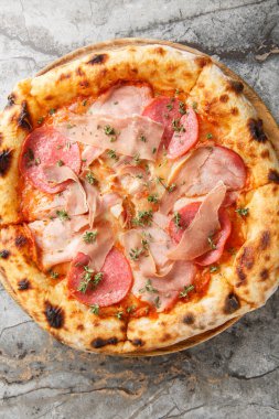 Napoli usulü etli pizza. Masadaki tahta tahtaya yakın plan salam otları. Yukarıdan dikey üst görünüm