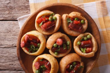 Yorkshire puddings with sausage and green peas closeup horizonta