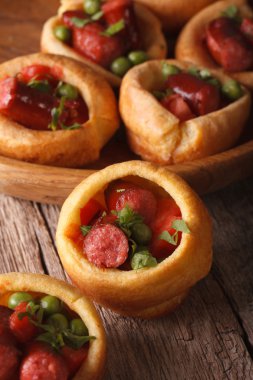 Yorkshire puddings stuffed with sausages close-up. Vertical