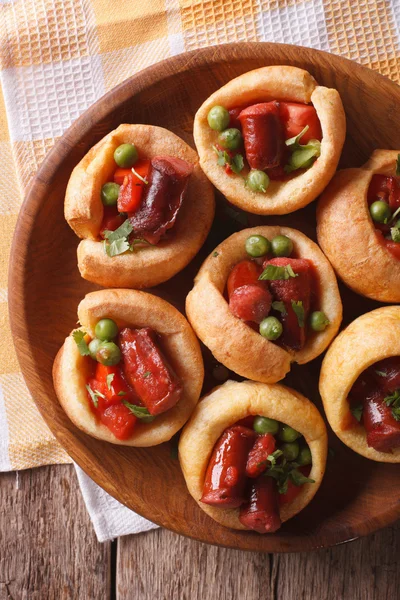 Budín Yorkshire con salchichas y guisantes verdes en primer plano vertical — Foto de Stock