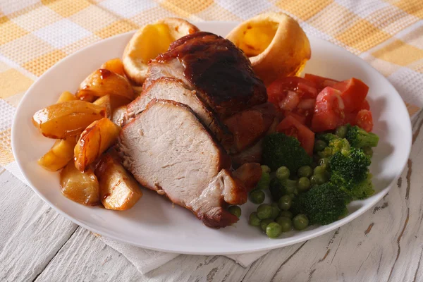 Sunday Roast: pork with vegetables and Yorkshire pudding closeup — Stock Photo, Image