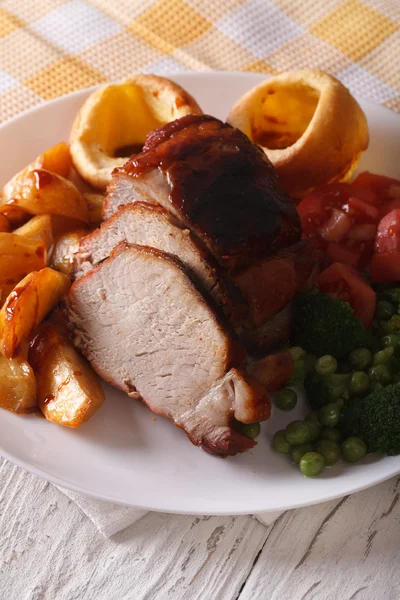 Pork with potatoes, fresh vegetables and Yorkshire pudding, vert — Stock Photo, Image