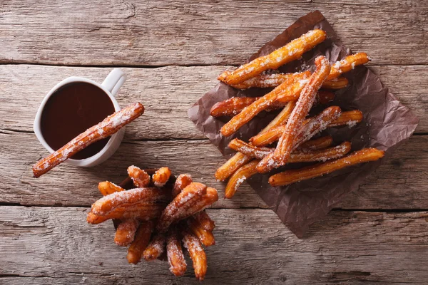 Churros e chocolate quente na mesa. vista horizontal superior — Fotografia de Stock