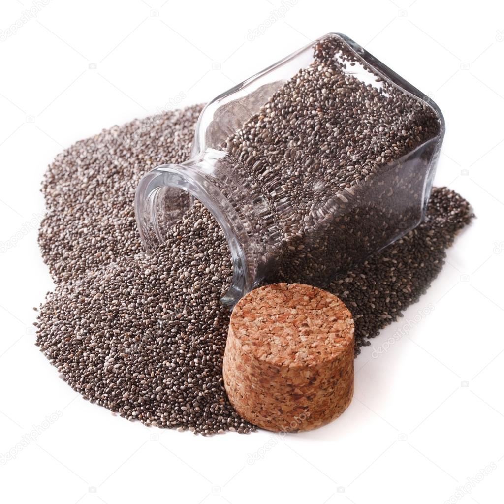 Carefully selected Chia seeds spill out of a jar close up isolat