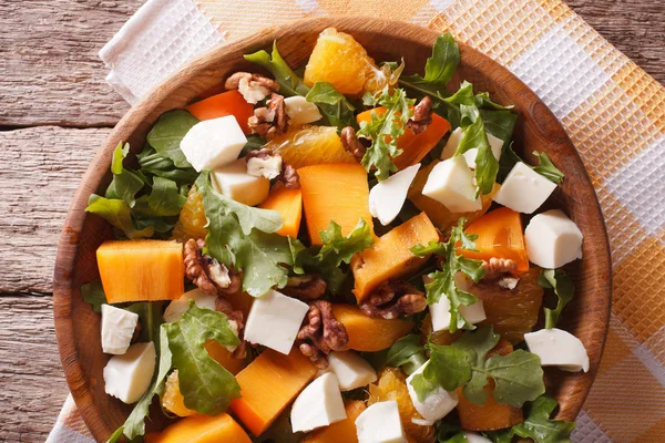 Salat mit Kaki, Nüssen, Rucola und Käse Nahaufnahme. Horizont — Stockfoto