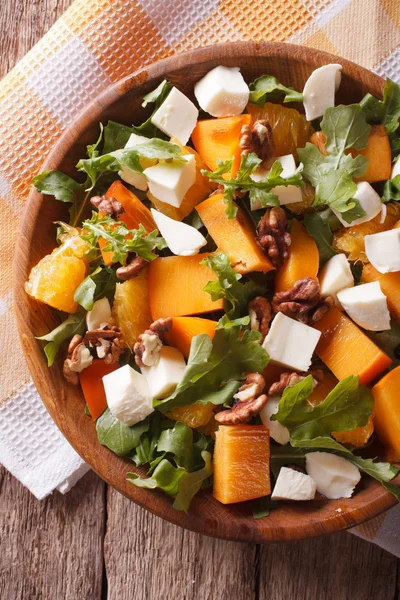 Salad with persimmon, nuts, arugula and cheese closeup. vertical — ストック写真