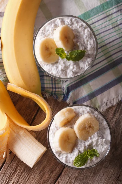 Budino con semi di chia e banana in un primo piano di vetro. verticale — Foto Stock