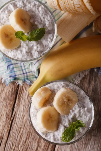 Yogurt con semi di chia e banana in un primo piano di vetro. verticale — Foto Stock