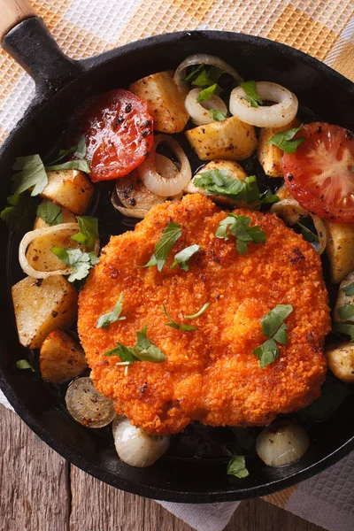 Zelfgemaakte schnitzel en groenten op pan close-up. verticale top — Stockfoto