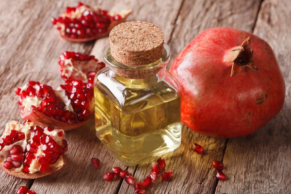 Granátové jablko olej ve skleněné láhvi na stůl. Horizontální — Stock fotografie