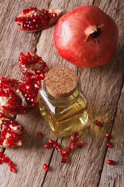 Granátové jablko olej ve skleněné láhvi na stůl. vertikální — Stock fotografie