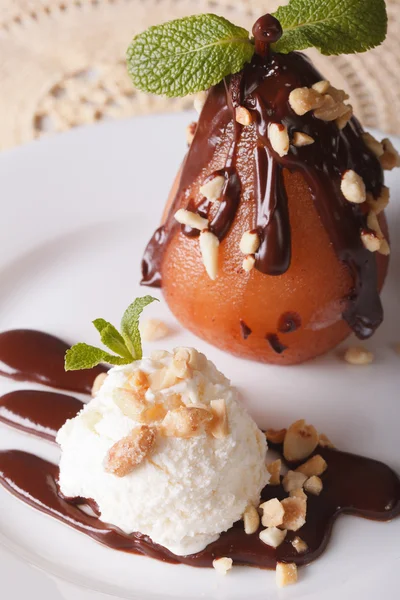 Pear in chocolate with nuts and vanilla ice cream close-up. vert — Stock Photo, Image