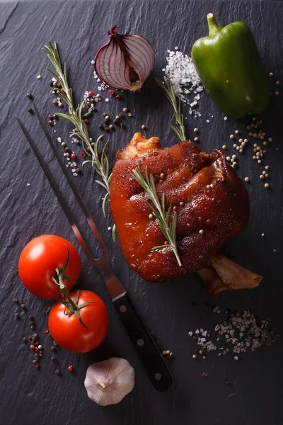Canela de porco cozida no forno, verduras e temperos em uma ardósia. parte superior vertical — Fotografia de Stock