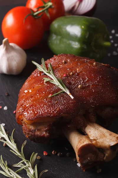 Baked pork shank and fresh vegetables closeup. vertical — Stock Photo, Image