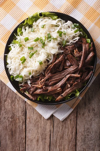 Du porc avec de la salade de chou sur la table. vue de dessus verticale — Photo