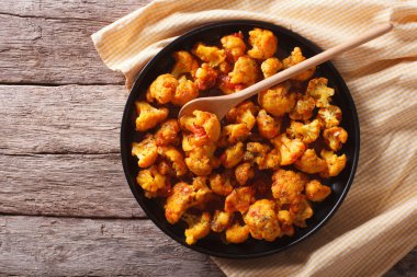 cauliflower with tomatoes in curry. Horizontal top view clipart