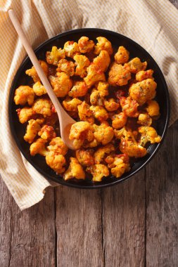 Asian food: cauliflower with tomatoes in curry. vertical top vie clipart