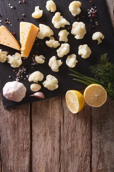 Cauliflower, cheese and spices on a slate board. vertical top vi — Stock Photo, Image