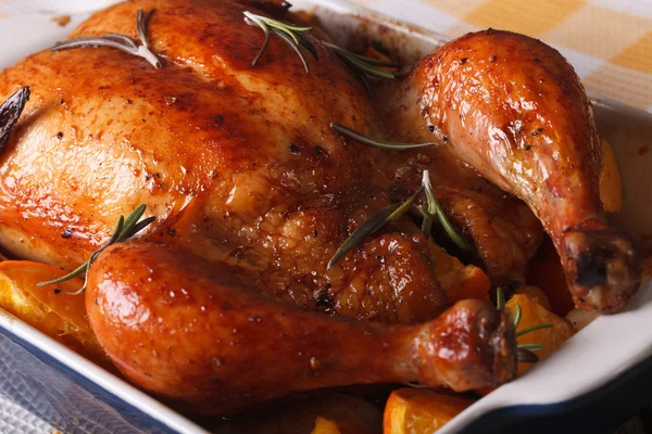 baked chicken with oranges in the baking dish close-up. horizont