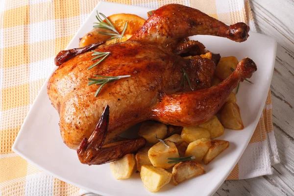 Frango assado com laranjas e batatas em uma chapa. horizontal — Fotografia de Stock