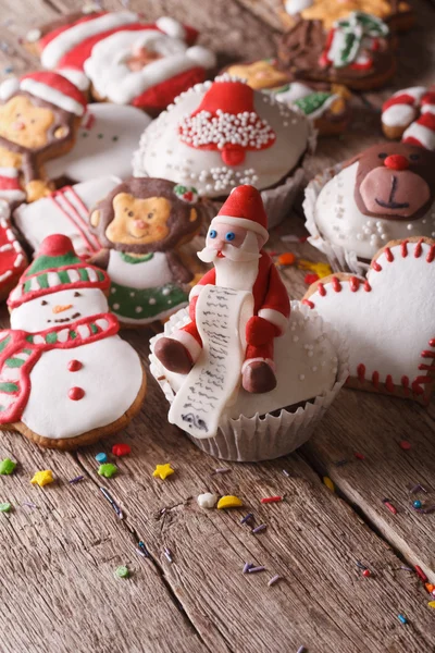 Cupcakes de Natal e pão de gengibre closeup em uma mesa de madeira. ve — Fotografia de Stock