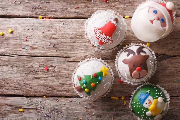 Christmas cupcakes closeup on a wooden table. Horizontal top vie — Stock Photo, Image