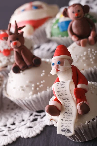 Bonitos cupcakes de Natal Papai Noel macro na mesa. vertical — Fotografia de Stock