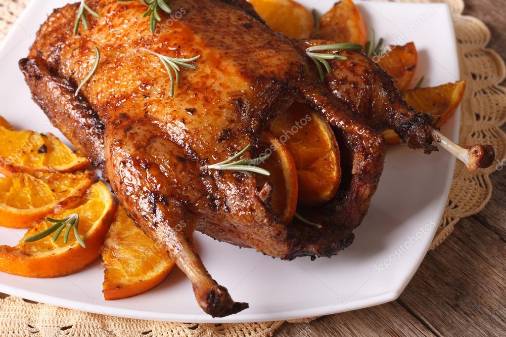 Whole roast duck with oranges and rosemary close up. horizontal Stock