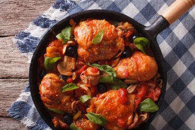 Cacciatori Chicken with black olives close-up in a pan. horizont