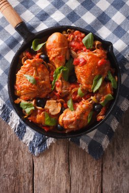 Cacciatori Chicken with mushrooms and olives in a pan. vertical 