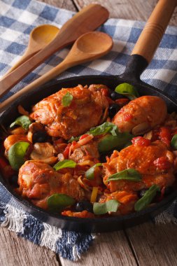 Italian cuisine: Chicken Cacciatori close up in a pan. vertical