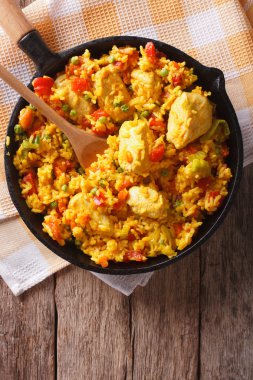 Hispanic cuisine: Arroz con pollo in a pan. vertical top view