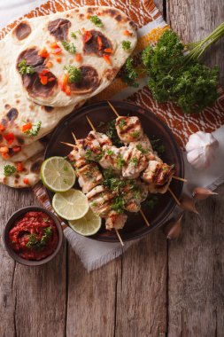 Tavuk tikka şişleri, düz ekmek ve Hint turşusu. Dikey üst v