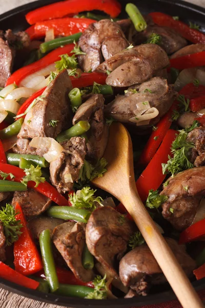 Hígado de pollo frito con verduras en una macro sartén. vertical — Foto de Stock