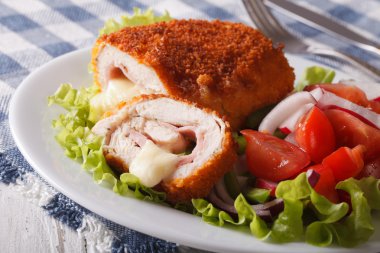 Dilimlenmiş tavuk cordon bleu ve salata yakın çekim. Yatay