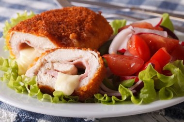 Tavuk cordon bleu kes ve bir salata yakın çekim. Yatay