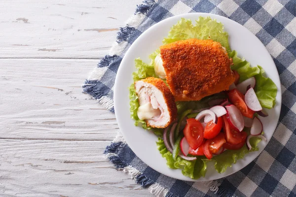 Chicken schnitzel cordon bleu and a salad. Horizontal top view — Stock Photo, Image