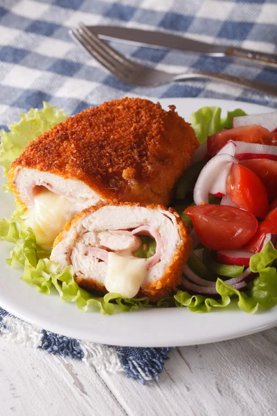 Delicious sliced Chicken cordon bleu and a salad close-up. Verti — Stock Photo, Image