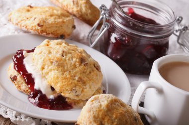 English pastries: scones with jam and tea with milk close-up. Ho clipart