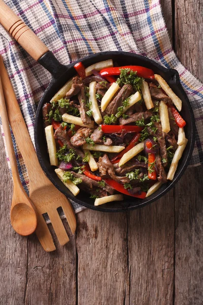 Comida peruana: Lomo saltado em uma frigideira. vista superior vertical — Fotografia de Stock