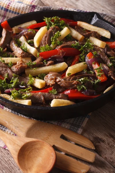 Carne de vaca com verduras e batatas fritas em uma panela close-up vertical — Fotografia de Stock