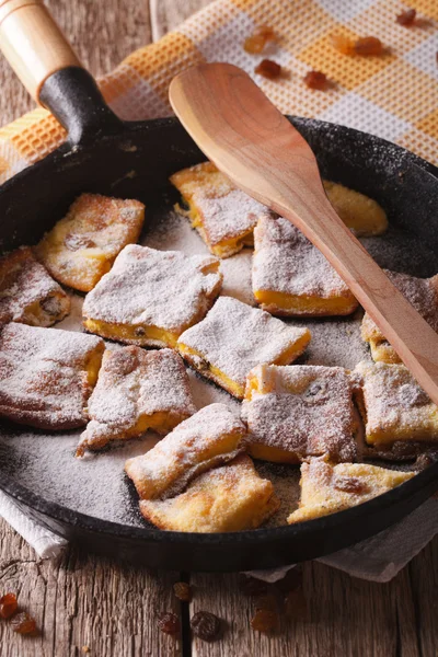 Sweet Kaiserschmarrn with raisins close-up in a frying pan. vert — Stock Photo, Image