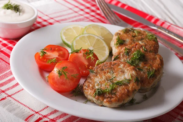 Hot fish cakes with lime and tomatoes on a plate and sauce. — Stock Photo, Image