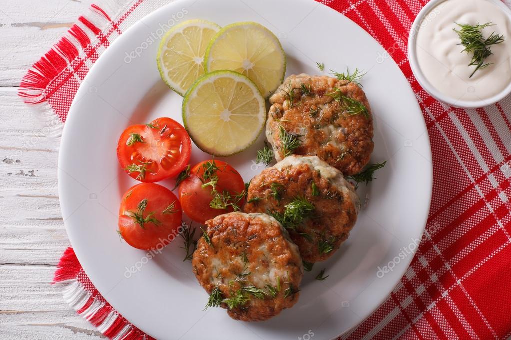 Fish cakes with dill sauce on the table closeup. Horizontal top