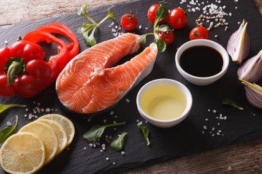 Çiğ somon ve malzemelerin üzerine ahşap bir masa kayrak bir yakın çekim