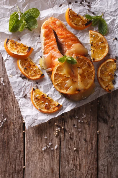 Salmón al horno con naranjas sobre la mesa. vista superior vertical —  Fotos de Stock